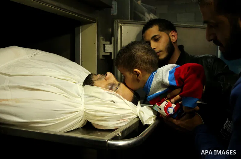 A Palestinian boy kisses the head of Hamas official, Mazen Faqha who was freed by Israel in a 2011 prisoner swap at a hospital morgue in Gaza City March 25, 2017. Faqha was released along with more than 1,000 other Pales...
