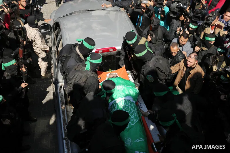 Members of the Ezzedine al-Qassam Brigades, the military wing of the Palestinian Islamist movement Hamas carry the body of Hamas official, Mazen Faqha who was freed by Israel in a 2011 prisoner swap during his funeral in...