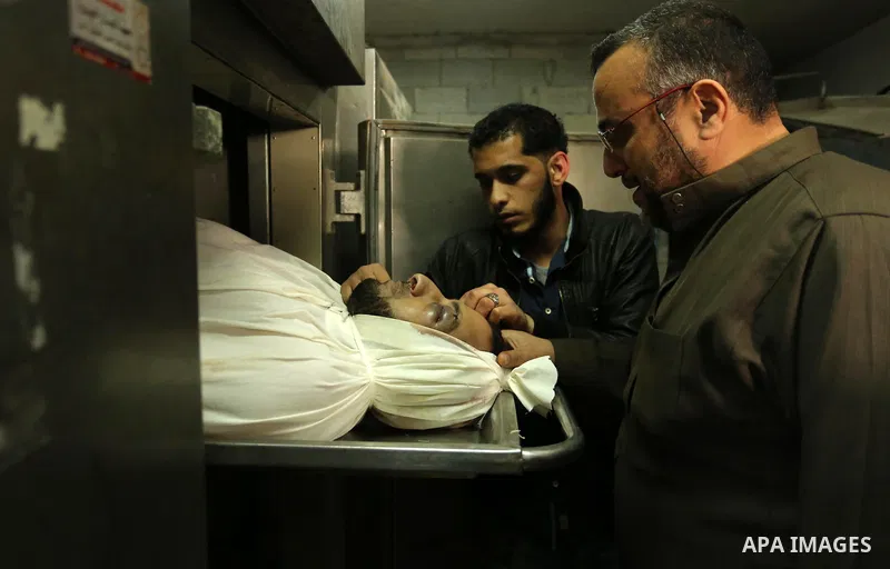 A Palestinian man looks at the body of of Hamas official, Mazen Faqha who was freed by Israel in a 2011 prisoner swap at a hospital morgue in Gaza City March 25, 2017. Faqha was released along with more than 1,000 other...