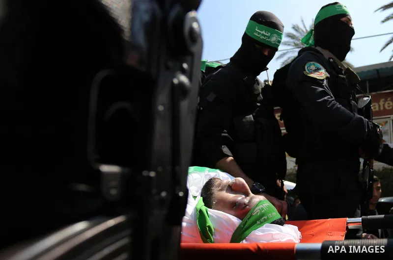 Members of the Ezzedine al-Qassam Brigades, the military wing of the Palestinian Islamist movement Hamas carry the body of Hamas official, Mazen Faqha who was freed by Israel in a 2011 prisoner swap during his funeral in...