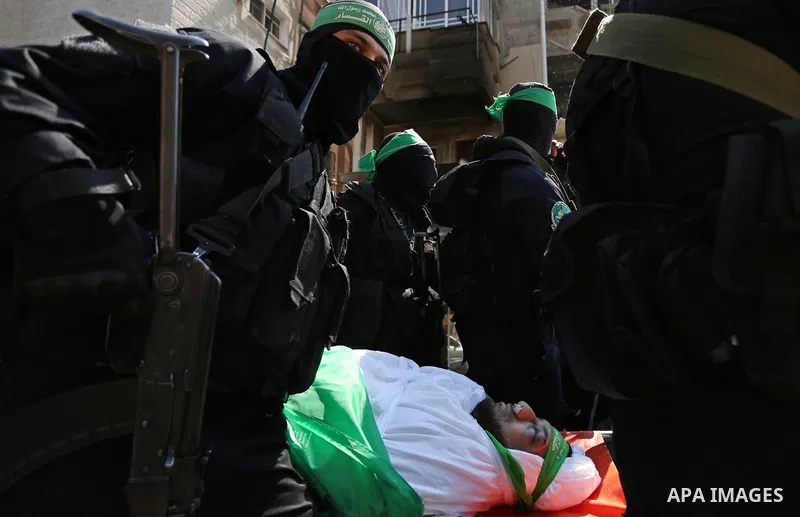 Members of the Ezzedine al-Qassam Brigades, the military wing of the Palestinian Islamist movement Hamas carry the body of Hamas official, Mazen Faqha who was freed by Israel in a 2011 prisoner swap during his funeral in...