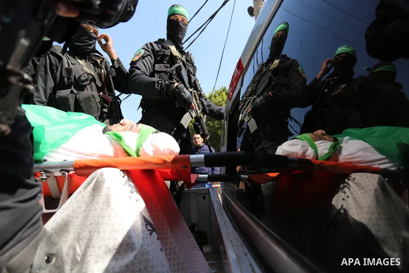 Members of the Ezzedine al-Qassam Brigades, the military wing of the Palestinian Islamist movement Hamas carry the body of Hamas official, Mazen Faqha who was freed by Israel in a 2011 prisoner swap during his funeral in...