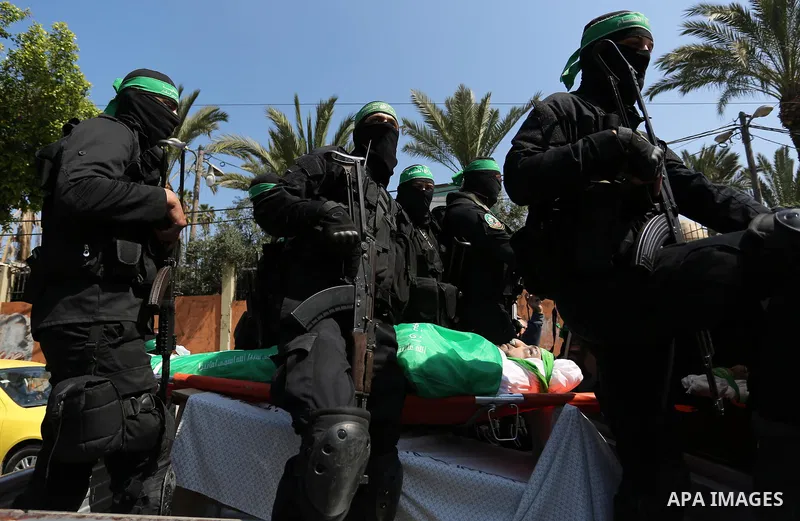 Members of the Ezzedine al-Qassam Brigades, the military wing of the Palestinian Islamist movement Hamas carry the body of Hamas official, Mazen Faqha who was freed by Israel in a 2011 prisoner swap during his funeral in...