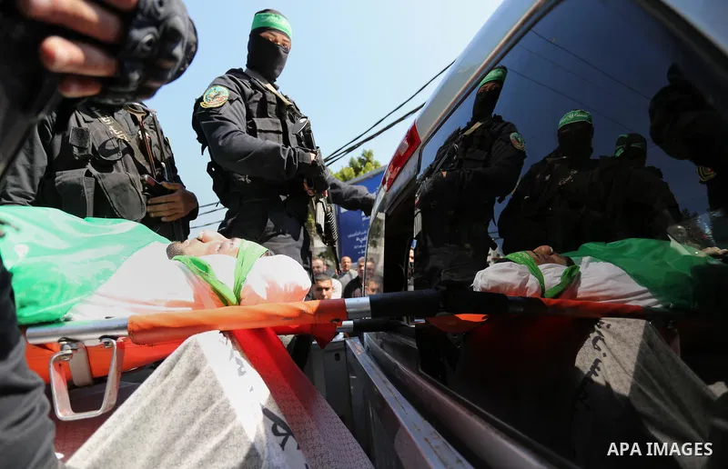 Members of the Ezzedine al-Qassam Brigades, the military wing of the Palestinian Islamist movement Hamas carry the body of Hamas official, Mazen Faqha who was freed by Israel in a 2011 prisoner swap during his funeral in...