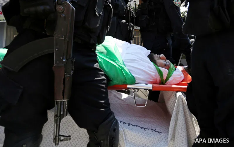 Members of the Ezzedine al-Qassam Brigades, the military wing of the Palestinian Islamist movement Hamas carry the body of Hamas official, Mazen Faqha who was freed by Israel in a 2011 prisoner swap during his funeral in...