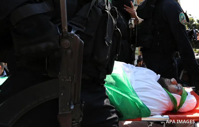 Members of the Ezzedine al-Qassam Brigades, the military wing of the Palestinian Islamist movement Hamas carry the body of Hamas official, Mazen Faqha who was freed by Israel in a 2011 prisoner swap during his funeral in...