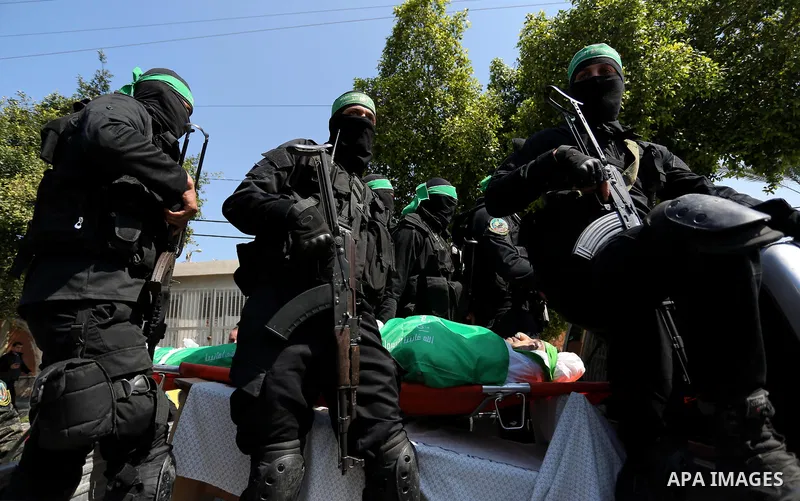 Members of the Ezzedine al-Qassam Brigades, the military wing of the Palestinian Islamist movement Hamas carry the body of Hamas official, Mazen Faqha who was freed by Israel in a 2011 prisoner swap during his funeral in...