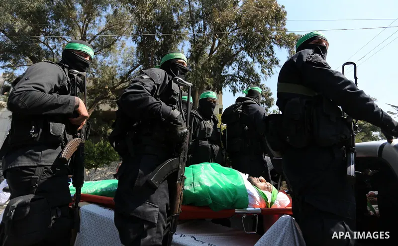 Members of the Ezzedine al-Qassam Brigades, the military wing of the Palestinian Islamist movement Hamas carry the body of Hamas official, Mazen Faqha who was freed by Israel in a 2011 prisoner swap during his funeral in...