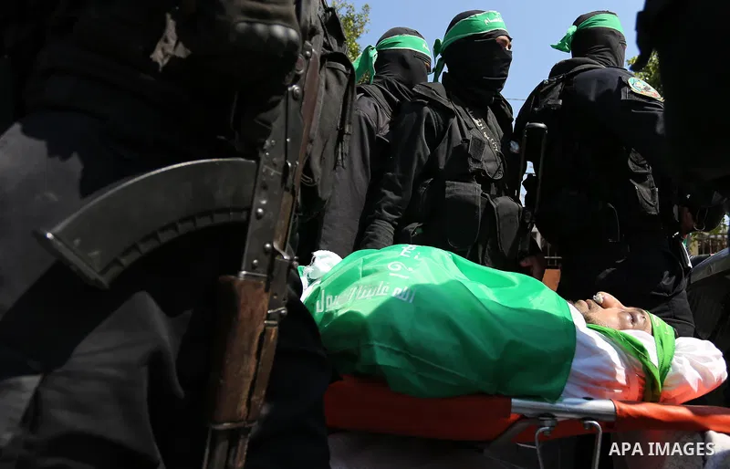 Members of the Ezzedine al-Qassam Brigades, the military wing of the Palestinian Islamist movement Hamas carry the body of Hamas official, Mazen Faqha who was freed by Israel in a 2011 prisoner swap during his funeral in...