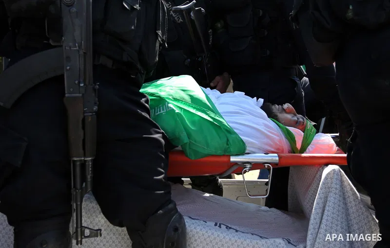 Members of the Ezzedine al-Qassam Brigades, the military wing of the Palestinian Islamist movement Hamas carry the body of Hamas official, Mazen Faqha who was freed by Israel in a 2011 prisoner swap during his funeral in...