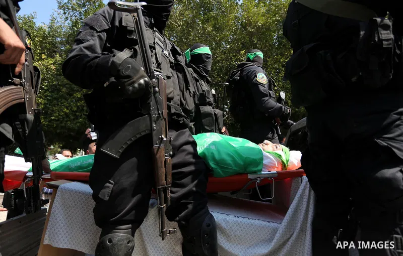 Members of the Ezzedine al-Qassam Brigades, the military wing of the Palestinian Islamist movement Hamas carry the body of Hamas official, Mazen Faqha who was freed by Israel in a 2011 prisoner swap during his funeral in...