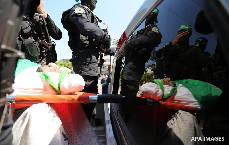 Members of the Ezzedine al-Qassam Brigades, the military wing of the Palestinian Islamist movement Hamas carry the body of Hamas official, Mazen Faqha who was freed by Israel in a 2011 prisoner swap during his funeral in...