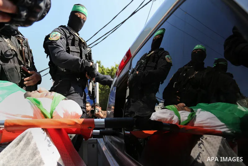 Members of the Ezzedine al-Qassam Brigades, the military wing of the Palestinian Islamist movement Hamas carry the body of Hamas official, Mazen Faqha who was freed by Israel in a 2011 prisoner swap during his funeral in...
