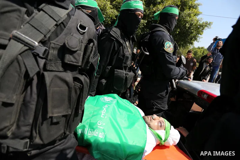 Members of the Ezzedine al-Qassam Brigades, the military wing of the Palestinian Islamist movement Hamas carry the body of Hamas official, Mazen Faqha who was freed by Israel in a 2011 prisoner swap during his funeral in...