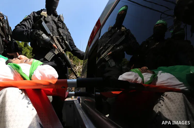 Members of the Ezzedine al-Qassam Brigades, the military wing of the Palestinian Islamist movement Hamas carry the body of Hamas official, Mazen Faqha who was freed by Israel in a 2011 prisoner swap during his funeral in...