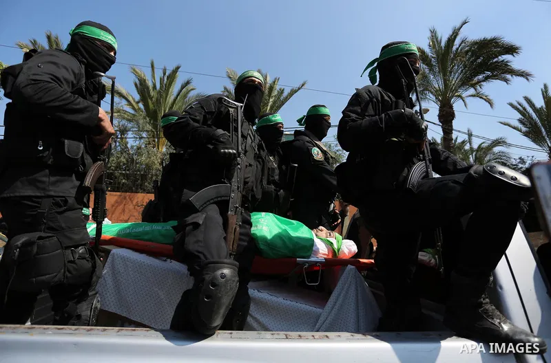 Members of the Ezzedine al-Qassam Brigades, the military wing of the Palestinian Islamist movement Hamas carry the body of Hamas official, Mazen Faqha who was freed by Israel in a 2011 prisoner swap during his funeral in...