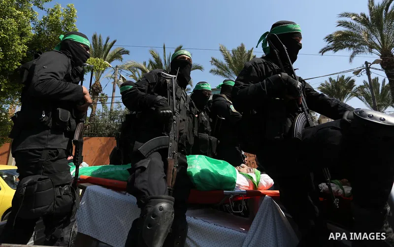 Members of the Ezzedine al-Qassam Brigades, the military wing of the Palestinian Islamist movement Hamas carry the body of Hamas official, Mazen Faqha who was freed by Israel in a 2011 prisoner swap during his funeral in...