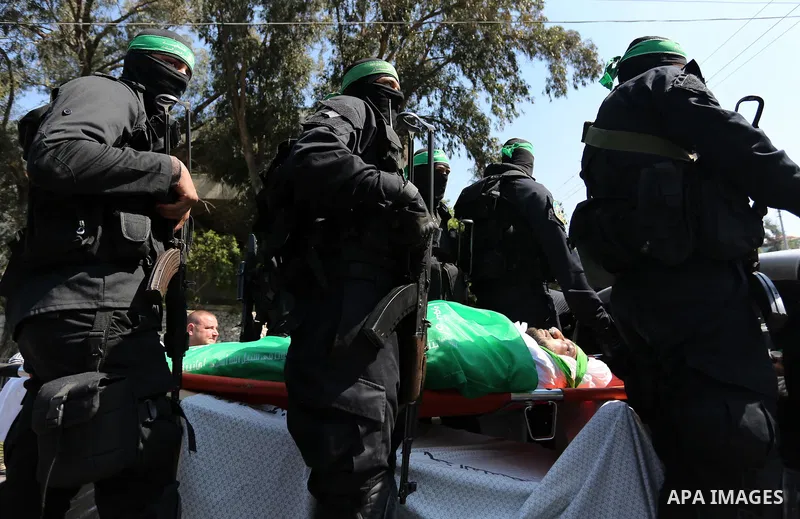 Members of the Ezzedine al-Qassam Brigades, the military wing of the Palestinian Islamist movement Hamas carry the body of Hamas official, Mazen Faqha who was freed by Israel in a 2011 prisoner swap during his funeral in...