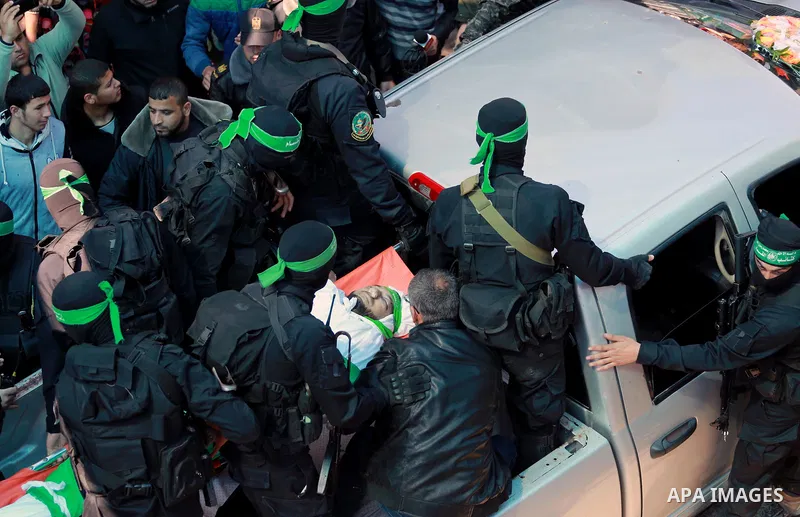 Members of the Ezzedine al-Qassam Brigades, the military wing of the Palestinian Islamist movement Hamas carry the body of Hamas official, Mazen Faqha who was freed by Israel in a 2011 prisoner swap during his funeral in...