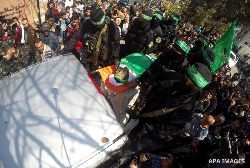 Members of the Ezzedine al-Qassam Brigades, the military wing of the Palestinian Islamist movement Hamas carry the body of Hamas official, Mazen Faqha who was freed by Israel in a 2011 prisoner swap during his funeral in...