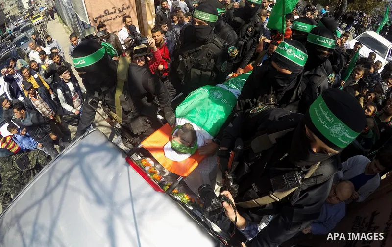 Members of the Ezzedine al-Qassam Brigades, the military wing of the Palestinian Islamist movement Hamas carry the body of Hamas official, Mazen Faqha who was freed by Israel in a 2011 prisoner swap during his funeral in...
