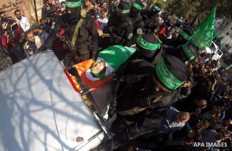 Members of the Ezzedine al-Qassam Brigades, the military wing of the Palestinian Islamist movement Hamas carry the body of Hamas official, Mazen Faqha who was freed by Israel in a 2011 prisoner swap during his funeral in...