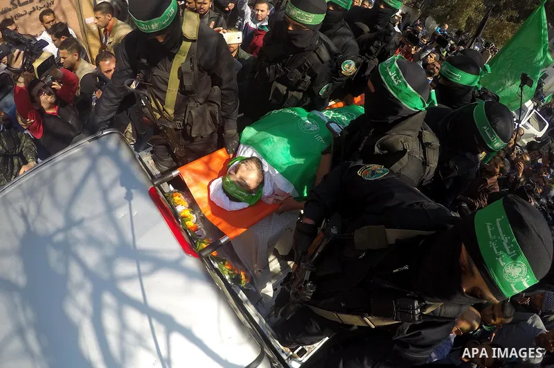 Members of the Ezzedine al-Qassam Brigades, the military wing of the Palestinian Islamist movement Hamas carry the body of Hamas official, Mazen Faqha who was freed by Israel in a 2011 prisoner swap during his funeral in...