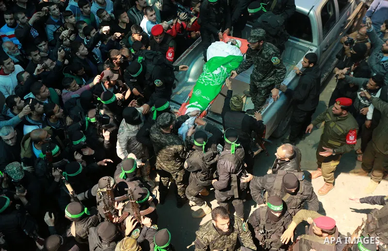 Members of the Ezzedine al-Qassam Brigades, the military wing of the Palestinian Islamist movement Hamas carry the body of Hamas official, Mazen Faqha who was freed by Israel in a 2011 prisoner swap during his funeral in...