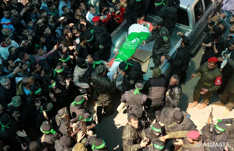Members of the Ezzedine al-Qassam Brigades, the military wing of the Palestinian Islamist movement Hamas carry the body of Hamas official, Mazen Faqha who was freed by Israel in a 2011 prisoner swap during his funeral in...