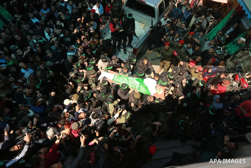 Members of the Ezzedine al-Qassam Brigades, the military wing of the Palestinian Islamist movement Hamas carry the body of Hamas official, Mazen Faqha who was freed by Israel in a 2011 prisoner swap during his funeral in...