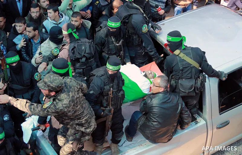 Members of the Ezzedine al-Qassam Brigades, the military wing of the Palestinian Islamist movement Hamas carry the body of Hamas official, Mazen Faqha who was freed by Israel in a 2011 prisoner swap during his funeral in...