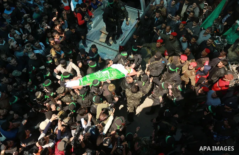 Members of the Ezzedine al-Qassam Brigades, the military wing of the Palestinian Islamist movement Hamas carry the body of Hamas official, Mazen Faqha who was freed by Israel in a 2011 prisoner swap during his funeral in...
