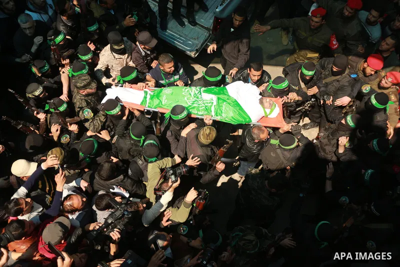 Members of the Ezzedine al-Qassam Brigades, the military wing of the Palestinian Islamist movement Hamas carry the body of Hamas official, Mazen Faqha who was freed by Israel in a 2011 prisoner swap during his funeral in...