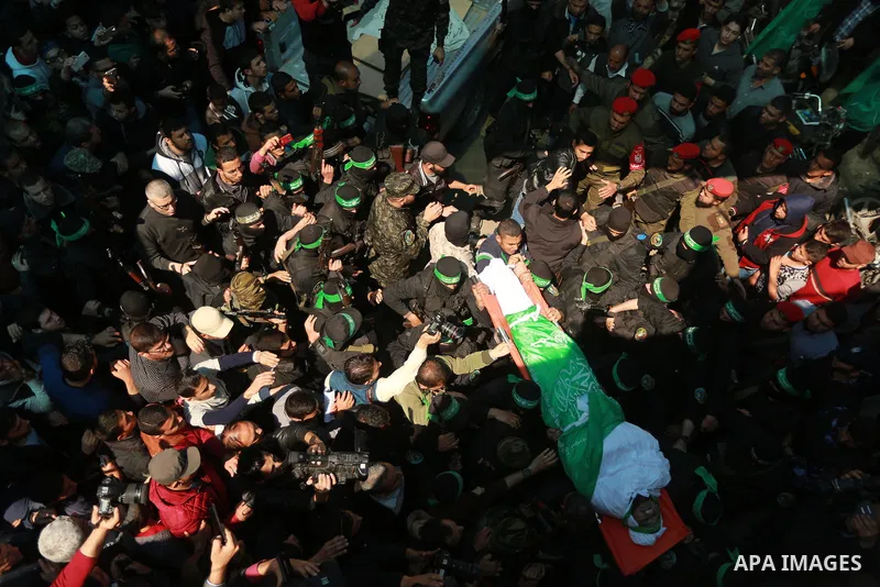 Members of the Ezzedine al-Qassam Brigades, the military wing of the Palestinian Islamist movement Hamas carry the body of Hamas official, Mazen Faqha who was freed by Israel in a 2011 prisoner swap during his funeral in...