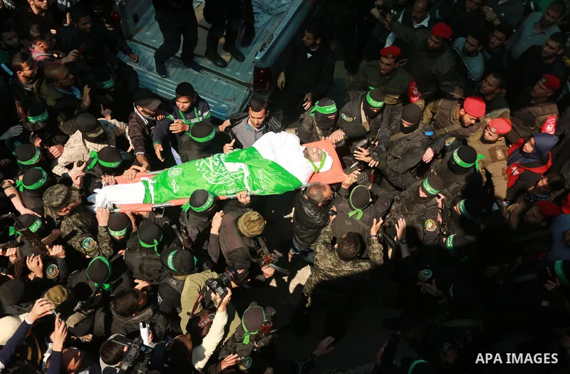 Members of the Ezzedine al-Qassam Brigades, the military wing of the Palestinian Islamist movement Hamas carry the body of Hamas official, Mazen Faqha who was freed by Israel in a 2011 prisoner swap during his funeral in...