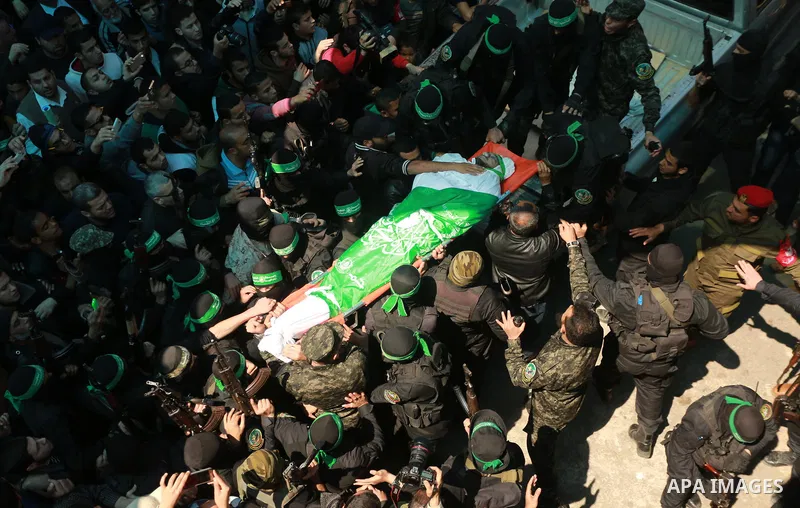 Members of the Ezzedine al-Qassam Brigades, the military wing of the Palestinian Islamist movement Hamas carry the body of Hamas official, Mazen Faqha who was freed by Israel in a 2011 prisoner swap during his funeral in...