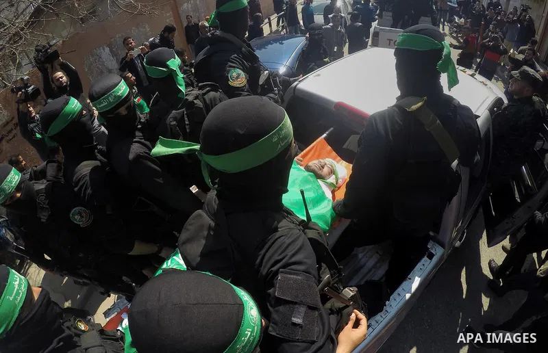 Members of the Ezzedine al-Qassam Brigades, the military wing of the Palestinian Islamist movement Hamas carry the body of Hamas official, Mazen Faqha who was freed by Israel in a 2011 prisoner swap during his funeral in...
