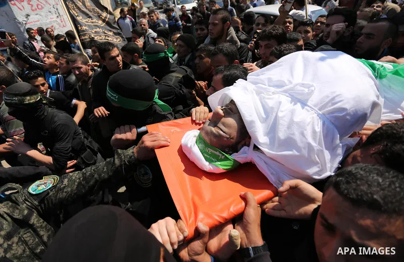 Members of the Ezzedine al-Qassam Brigades, the military wing of Hamas carry the body of Palestinian Islamist movement Hamas' official Mazen Faqha, during his funeral in Gaza city on March 25, 2017. Gunmen in the Gaza St...