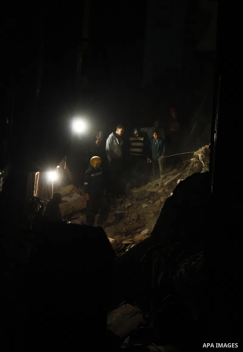 Egyptian civil defense members inspect the damage in front of the collapsed building in Boulak Abou El Ela, in Cairo on March 25, 2017. Photo by Amr Sayed