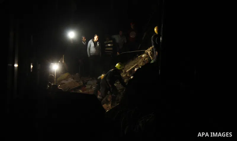 Egyptian civil defense members inspect the damage in front of the collapsed building in Boulak Abou El Ela, in Cairo on March 25, 2017. Photo by Amr Sayed