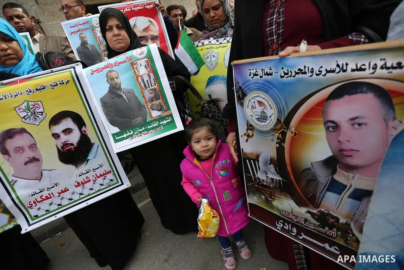 Palestinians hold placards during a protest to show solidarity with Palestinian prisoners held in Israeli Jails, in front of Red cross office in Gaza city, on March 27, 2017. Photo by Ashraf Amra