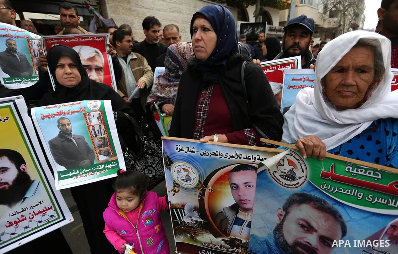 Palestinians hold placards during a protest to show solidarity with Palestinian prisoners held in Israeli Jails, in front of Red cross office in Gaza city, on March 27, 2017. Photo by Ashraf Amra