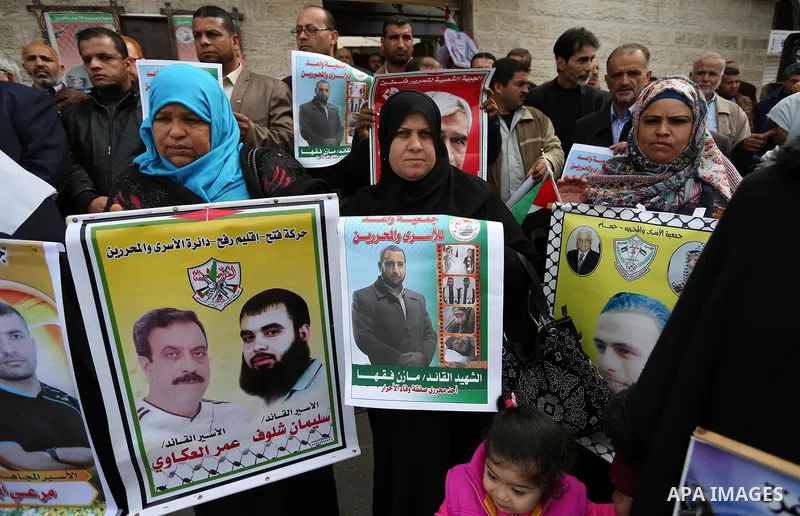 Palestinians hold placards during a protest to show solidarity with Palestinian prisoners held in Israeli Jails, in front of Red cross office in Gaza city, on March 27, 2017. Photo by Ashraf Amra