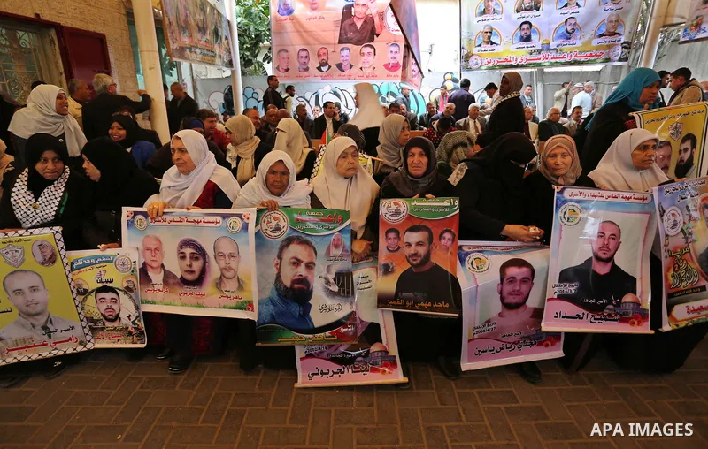Palestinians hold placards during a protest to show solidarity with Palestinian prisoners held in Israeli Jails, in front of Red cross office in Gaza city, on March 27, 2017. Photo by Ashraf Amra