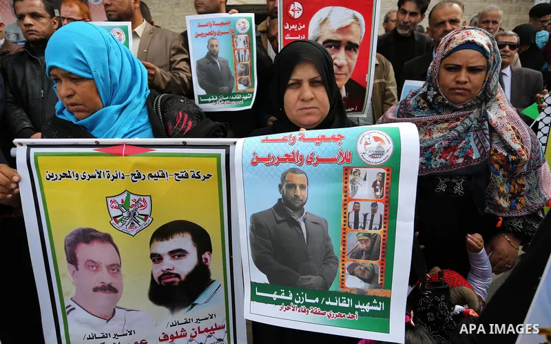 Palestinians hold placards during a protest to show solidarity with Palestinian prisoners held in Israeli Jails, in front of Red cross office in Gaza city, on March 27, 2017. Photo by Ashraf Amra