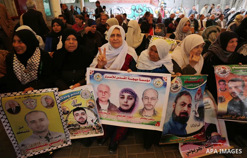 Palestinians hold placards during a protest to show solidarity with Palestinian prisoners held in Israeli Jails, in front of Red cross office in Gaza city, on March 27, 2017. Photo by Ashraf Amra