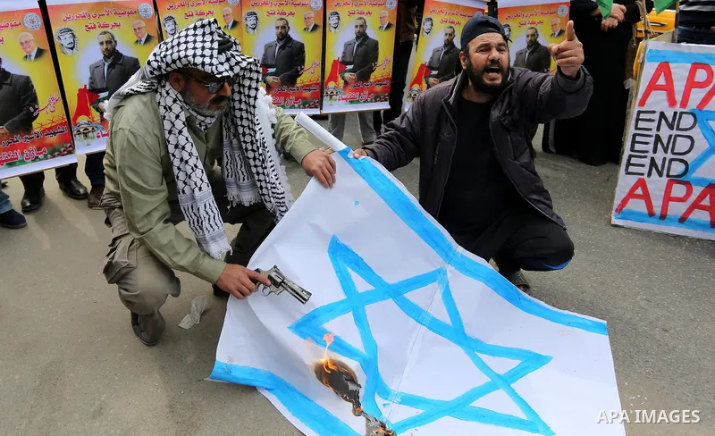 Palestinians burn an Israeli flag during a protest denouncing an assassination of Hamas official, Mazen Faqha who was freed by Israel in a 2011 prisoner swap after he was shot dead by unknown gunmen, in front of Red cros...