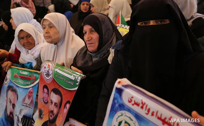 Palestinians hold placards during a protest to show solidarity with Palestinian prisoners held in Israeli Jails, in front of Red cross office in Gaza city, on March 27, 2017. Photo by Ashraf Amra
