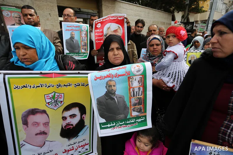 Palestinians hold placards during a protest to show solidarity with Palestinian prisoners held in Israeli Jails, in front of Red cross office in Gaza city, on March 27, 2017. Photo by Ashraf Amra