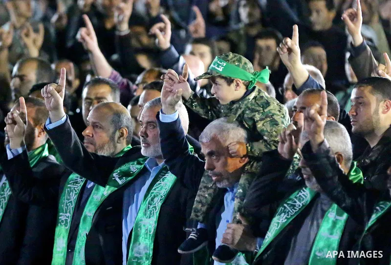 The son of Hamas official, Mazen Faqha, who was shot dead by unknown gunmen sits on the shoulders of Yahya Sinwar, the new leader of Hamas in the Gaza Strip during a memorial service in Gaza city on March 27, 2017. Photo...